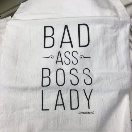 a white cotton kitchen towel with the words bad ass boss lady