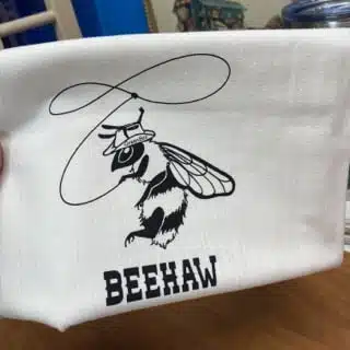 funny towel with a pun, towel has a cowboy bee with a cowboy hat and a lasso that says BeeHaw slightly flawed kitchen tea towel